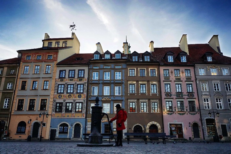 Girl with red backpack at the pump on the Old Town, Warsaw, Poland